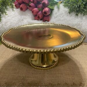 Golden 8” cake stand. Approximately 8” tall. Useful for any occasion.